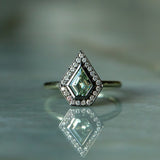 0.70ct Shield Cut Montana Sapphire and Blackened Gold Bezel Set Diamond Halo In 14k Green Gold