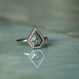 0.70ct Shield Cut Montana Sapphire and Blackened Gold Bezel Set Diamond Halo In 14k Green Gold