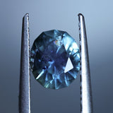 1.73CT PRECISION CUT OVAL MONTANA SAPPHIRE, DENIM PARTI TEAL WITH EARTHY INCLUSIONS, 7.47X6.16X4.69MM