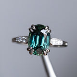 4.26ct Oval Deep Teal Madagascar Sapphire Double Claw Prong Low Profile Milgrain and Diamond Ring in Platinum