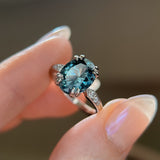 3.94ct Oval Unheated Deep Teal Blue Australian Sapphire Double Claw Prong Low Profile Milgrain and Diamond Ring in Platinum