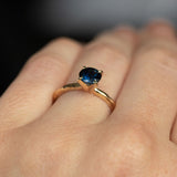 1.03ct Round Blue Australian Sapphire Evergreen Solitaire in 14k Yellow Gold on hand