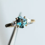 2.11ct Oval Color Shifting Madagascar Sapphire and Diamond Three Stone Ring in 14k Yellow Gold in tweezers