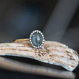 2.40ct Oval Cabochon Montana Sapphire and Antiqued Six Prong Low Profile Halo Ring in 14k Yellow Gold on shell