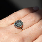 2.40ct Oval Cabochon Montana Sapphire and Antiqued Six Prong Low Profile Halo Ring in 14k Yellow Gold on hand