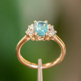 1.47ct Radiant Opalescent Teal Sapphire and White Sapphire Three Stone Ring in 14k Yellow Gold