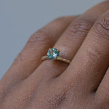 1.01ct Round Blue Montana Sapphire Evergreen Solitaire Ring in 14k Yellow Gold on the hand