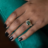 4.52ct Forest Green Radiant Cut Sapphire Double Claw Prong Solitaire with Diamonds in 14k Yellow Gold on hand with v band