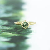 1.56ct Cushion Cut Sapphire With Milgrain Bezel Set In 18k Yellow Gold Brushed Finish on table