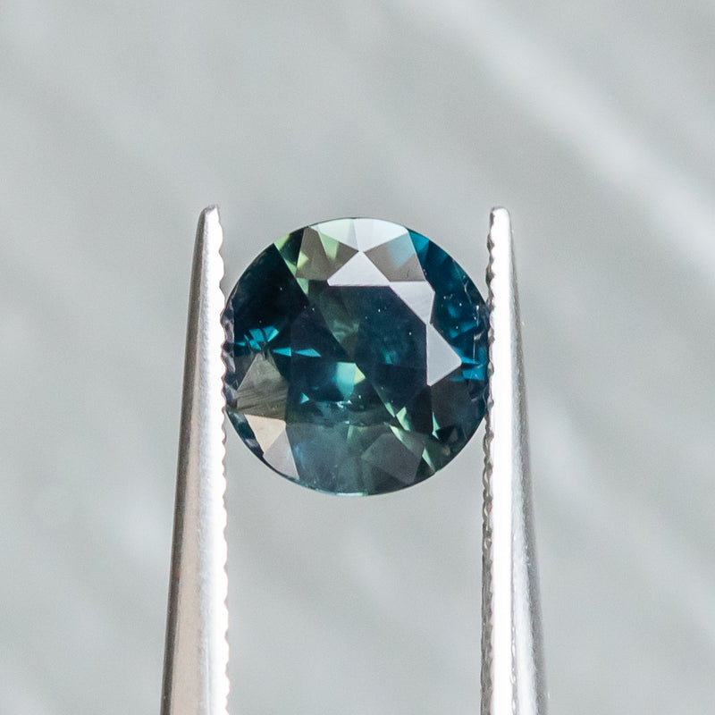 1.59CT ROUND NIGERIAN SAPPHIRE, DEEP TEAL WITH PARTI GREEN, 7.00X4.34MM, UNTREATED