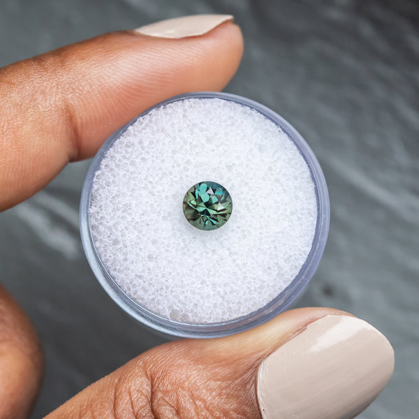 1.04CT BRILLIANT ROUND MADAGASCAR SAPPHIRE, COLOR SHIFTING TEAL BLUE GREEN TO WARM GREY, 5.97X4.19MM