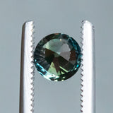 1.04CT BRILLIANT ROUND MADAGASCAR SAPPHIRE, COLOR SHIFTING TEAL BLUE GREEN TO WARM GREY, 5.97X4.19MM