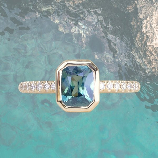 1.27ct Radiant Cut Madagascar Teal Sapphire Low Profile Bezel Solitaire Ring with French Set Diamonds in 14k Yellow Gold