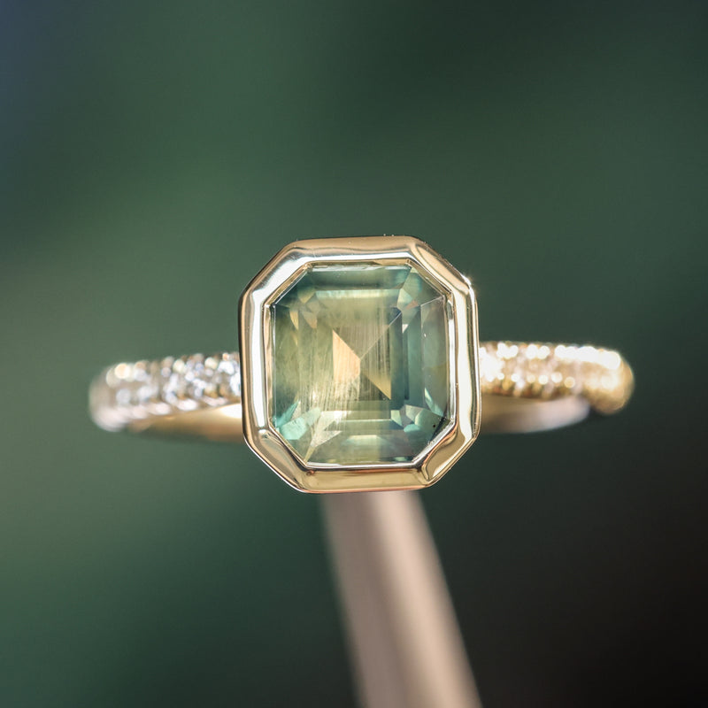 2.18ct Emerald Cut Parti Madagascar Sapphire Low Profile Bezel Solitaire Ring with Pavé Set Diamonds in 14k Green Gold