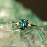 1.98ct Oval Precision Cut Teal Montana Sapphire and Princess Cut Diamond Rapids Low Profile Ring in 14k Yellow Gold