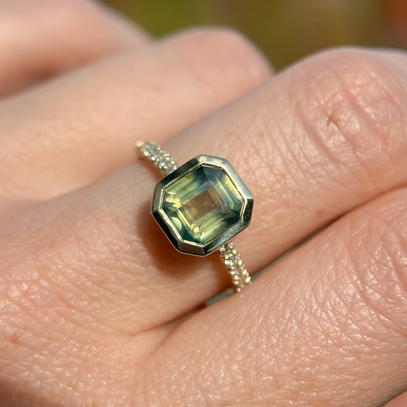 2.18ct Emerald Cut Parti Madagascar Sapphire Low Profile Bezel Solitaire Ring with Pavé Set Diamonds in 14k Green Gold