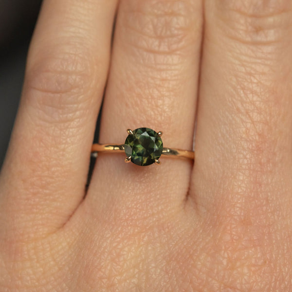 1.01ct Round Earthy Sapphire Evergreen Solitaire in 14k Yellow Gold on hand