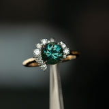 2.04ct Australian Teal Sapphire and Asymmetrical Diamond Cluster Ring in 14k Yellow and 14k White Gold in tweezers