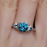 1.80ct Blue Montana Sapphire and Grey Spinel Three Stone Low Profile Evergreen Ring in Platinum on hand
