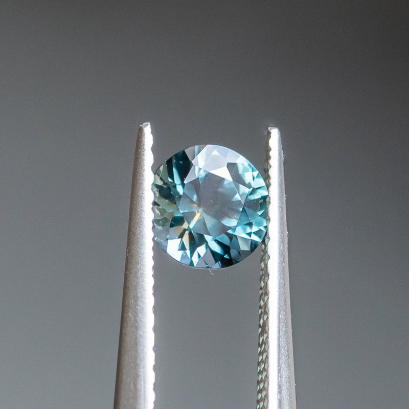 0.83CT ROUND BRILLIANT SONGEA SAPPHIRE, DENIM BLUE WITH BRIGHT TEAL FLASHES, 5.60X3.70MM