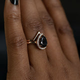 2.44ct Black Pear Diamond in 14k Rose Gold Diamond Halo Setting on hand angled with gold v band