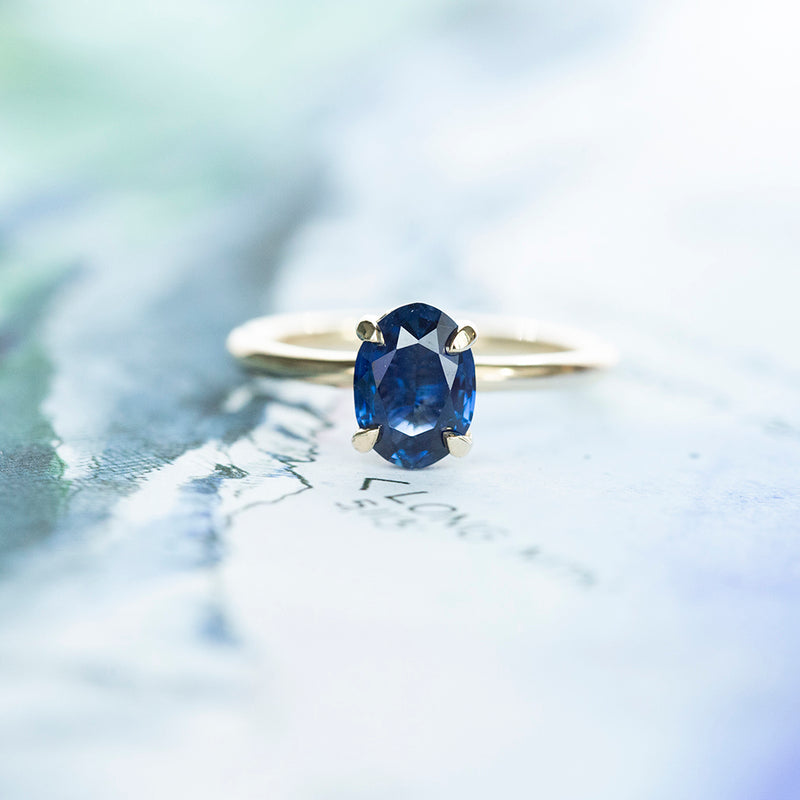 1.53ct Oval Royal Blue Sapphire Solitaire Ring In 14K Yellow Gold on table