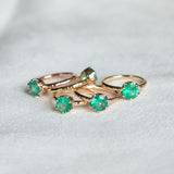 Neon Emerald Low Profile Six Prong Antique Evergreen Solitaires in 14k Yellow and Rose Gold many on table