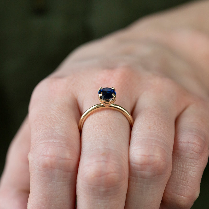 1.53ct Oval Royal Blue Sapphire Solitaire Ring In 14K Yellow Gold on hand