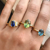 4.21ct Oval Parti Sapphire and Tapered Baguette Diamond Ring in 18k Yellow Gold on ring with other sapphire and yellow gold rings